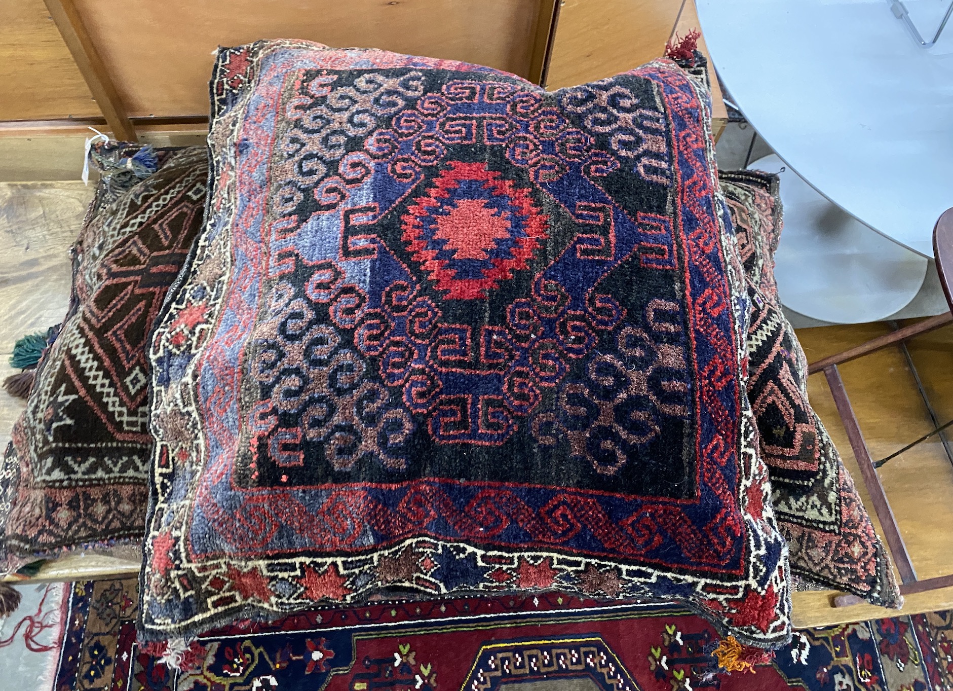 Two Afghan carpet cushions, larger 110 x 68cm